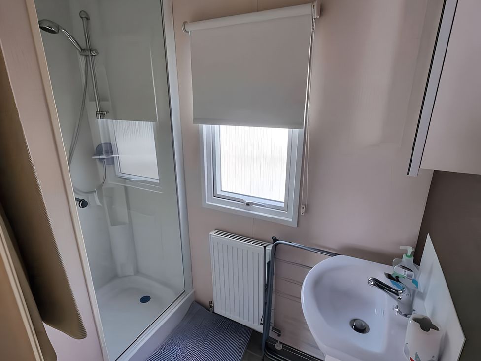 A bathroom with a shower and sink at 48 Woodland View in Lymington