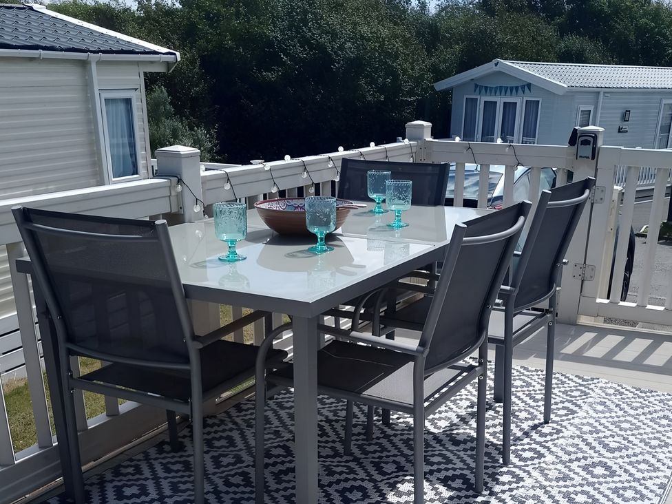 An outdoor dining area with table and chairs at 48 Woodland View Lymington