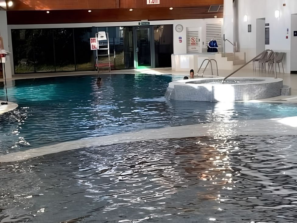 An indoor pool with a hot tub and pool steps at 48 Woodland View, Lymington