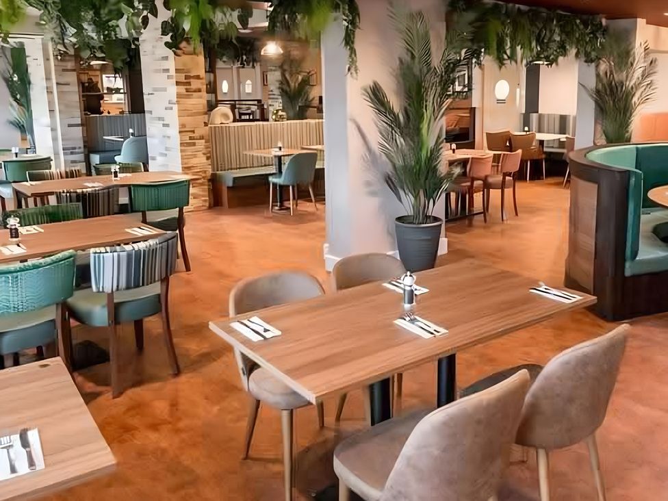 A dining room with tables and chairs at 48 Woodland View in Lymington