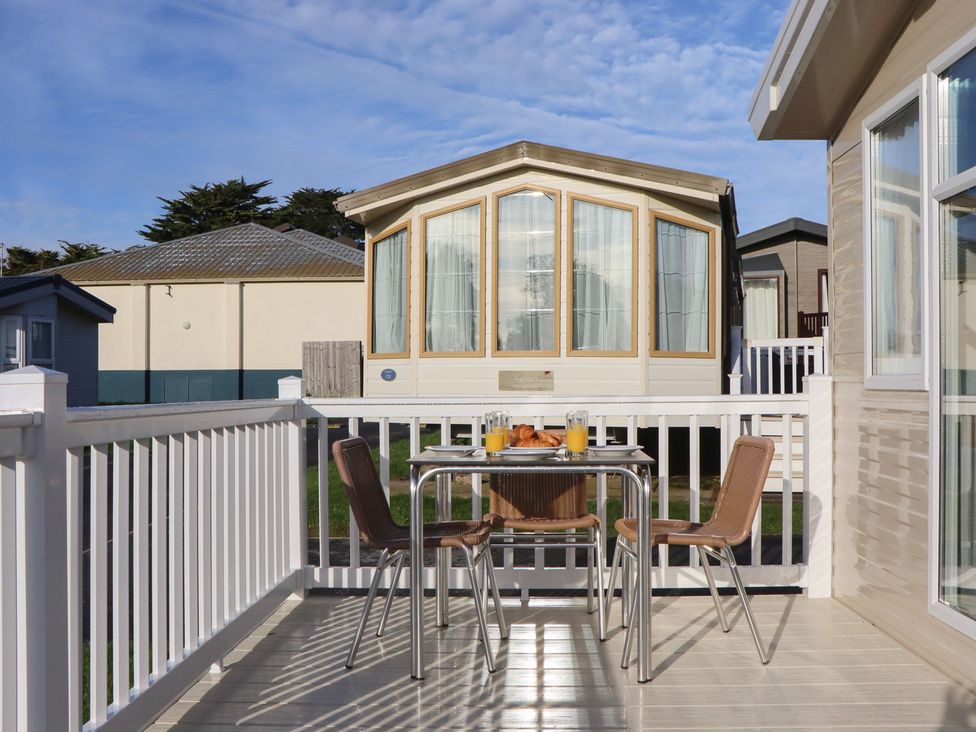 A table with drinks and croissants on an outdoor balcony at Caravan C32 at Landscove Holiday Park Brixham