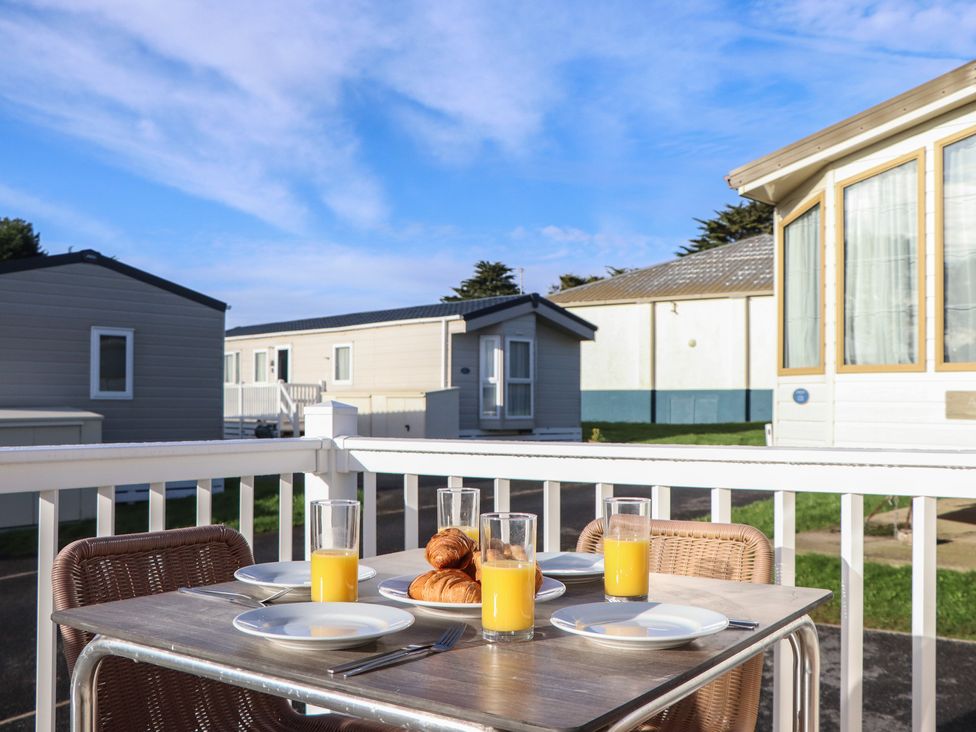 An outdoor table set with plates and drinks at Caravan C32 at Landscove Holiday Park Brixham