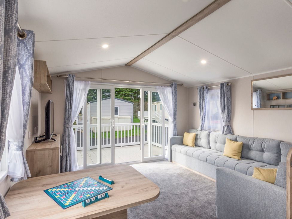 A living room with a sofa and a table at Caravan C32 at Landscove Holiday Park in Brixham