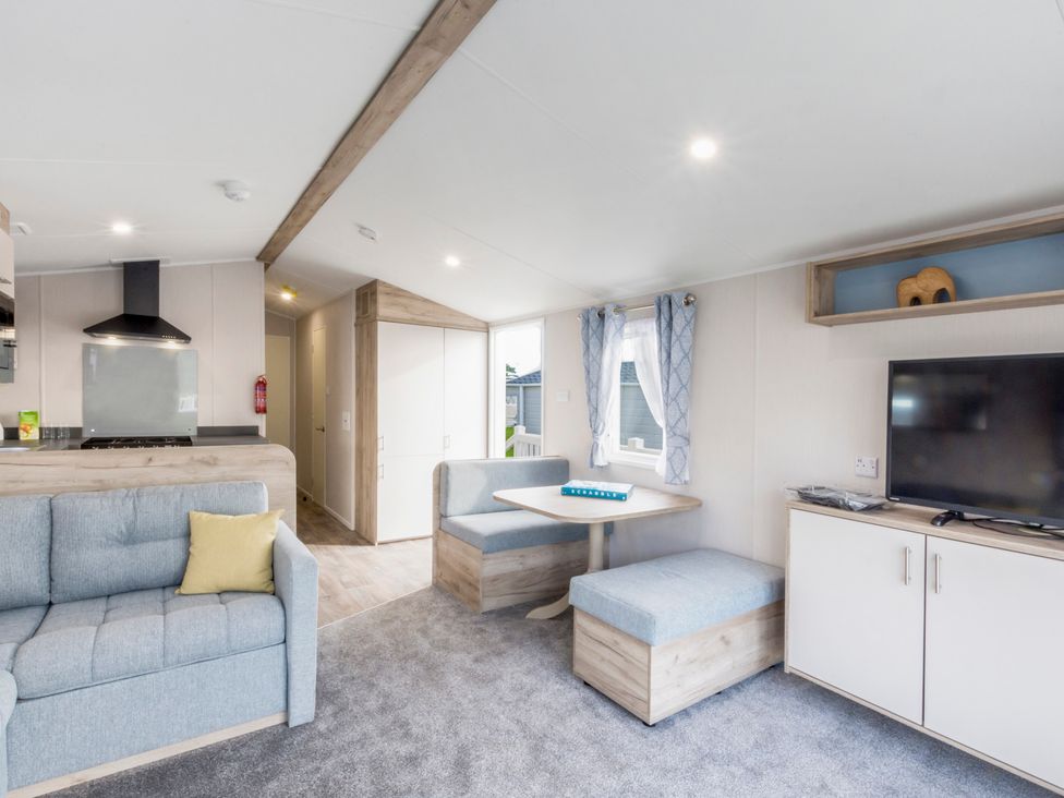 A living room with sofa and dining table at Caravan C32 at Landscove Holiday Park Brixham