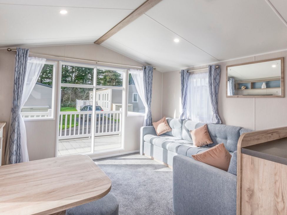A living room with a sofa and table at Caravan C32 at Landscove Holiday Park Brixham