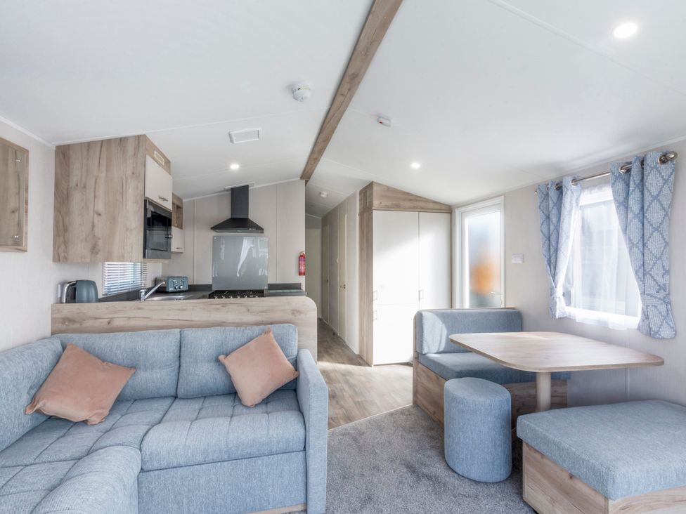 A living room with a sofa and dining area at Caravan C32 at Landscove Holiday Park Brixham