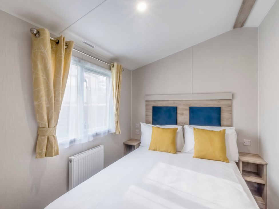 A bedroom with a bed and window at Caravan C32 at Landscove Holiday Park Brixham