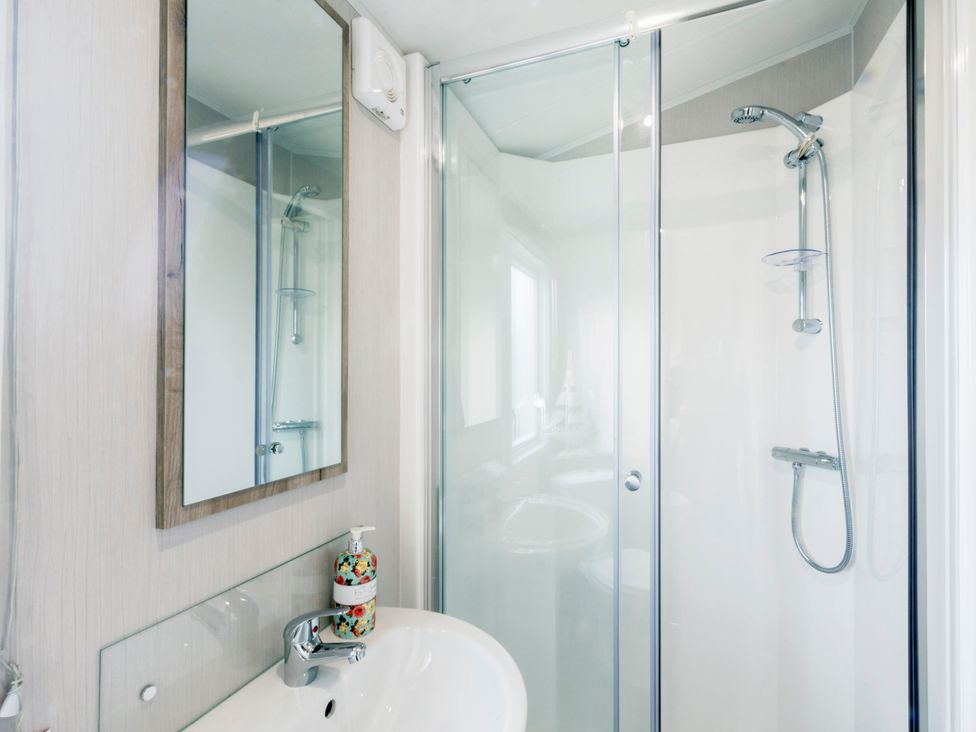 A bathroom with a shower and sink at Caravan C32 at Landscove Holiday Park Brixham