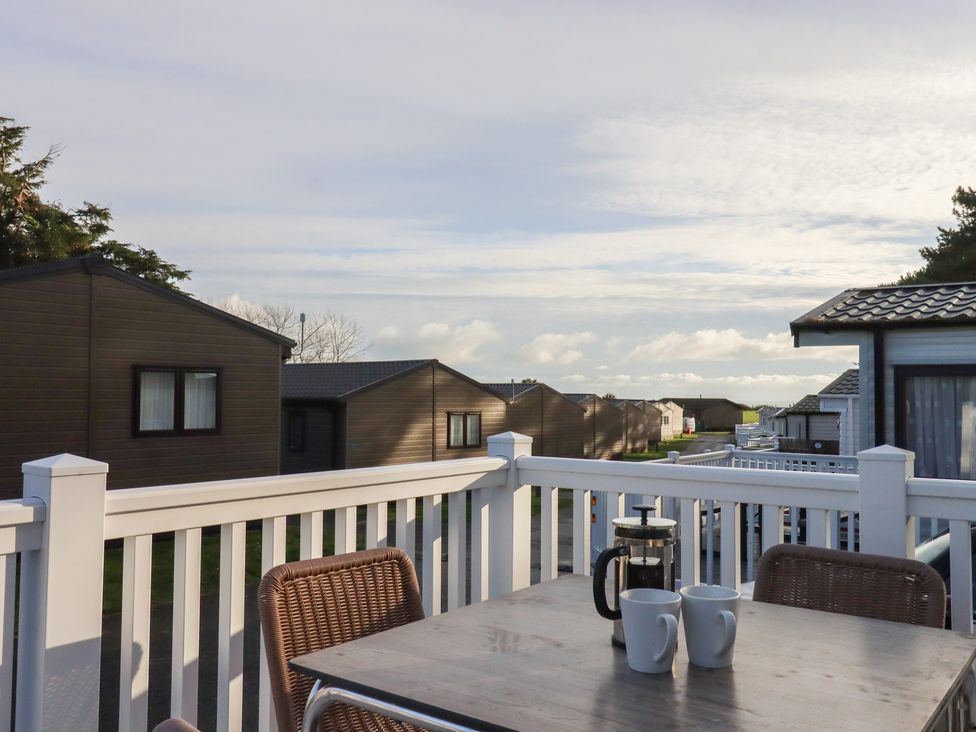 An outdoor area with a table and coffee cups at Caravan A24 at Landscove Holiday Park Brixham
