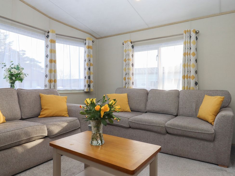 A living room with a sofa and coffee table at Caravan A24 at Landscove Holiday Park Brixham