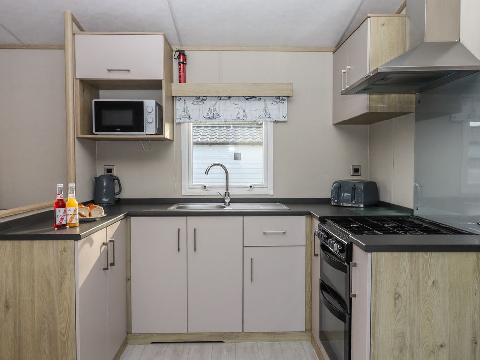 A kitchen with a sink and appliances at Caravan A24 at Landscove Holiday Park Brixham