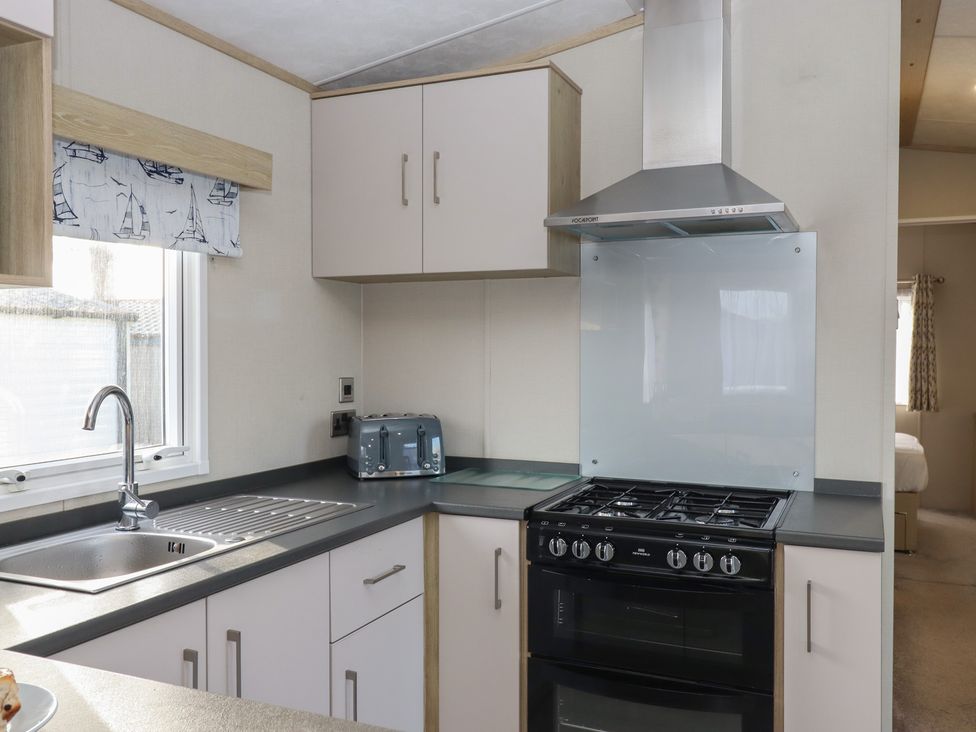 A kitchen with a sink and stove at Caravan A24 at Landscove Holiday Park in Brixham