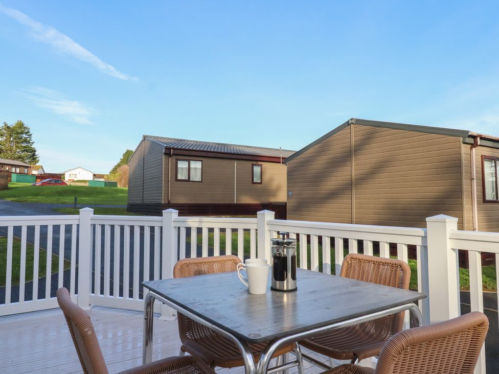 An outdoor seating area with a table and chairs at Caravan A24 at Landscove Holiday Park Brixham