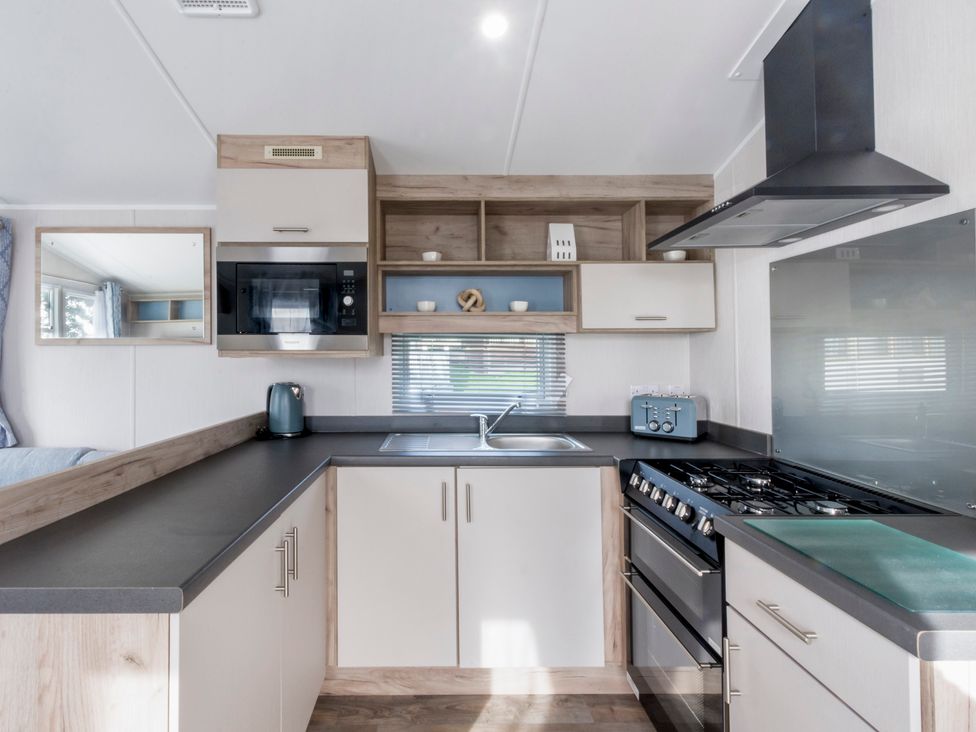 A kitchen with appliances and storage at Caravan A24 at Landscove Holiday Park Brixham