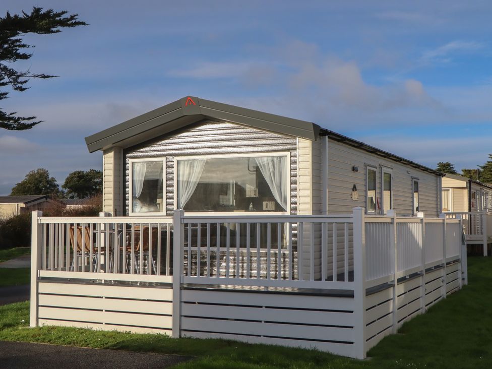 A caravan with a deck and seating area at Caravan B61 at Landscove Holiday Park in Brixham