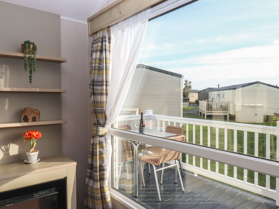 A living room with a view of the balcony and outdoor area at Caravan B61 at Landscove Holiday Park, Brixham