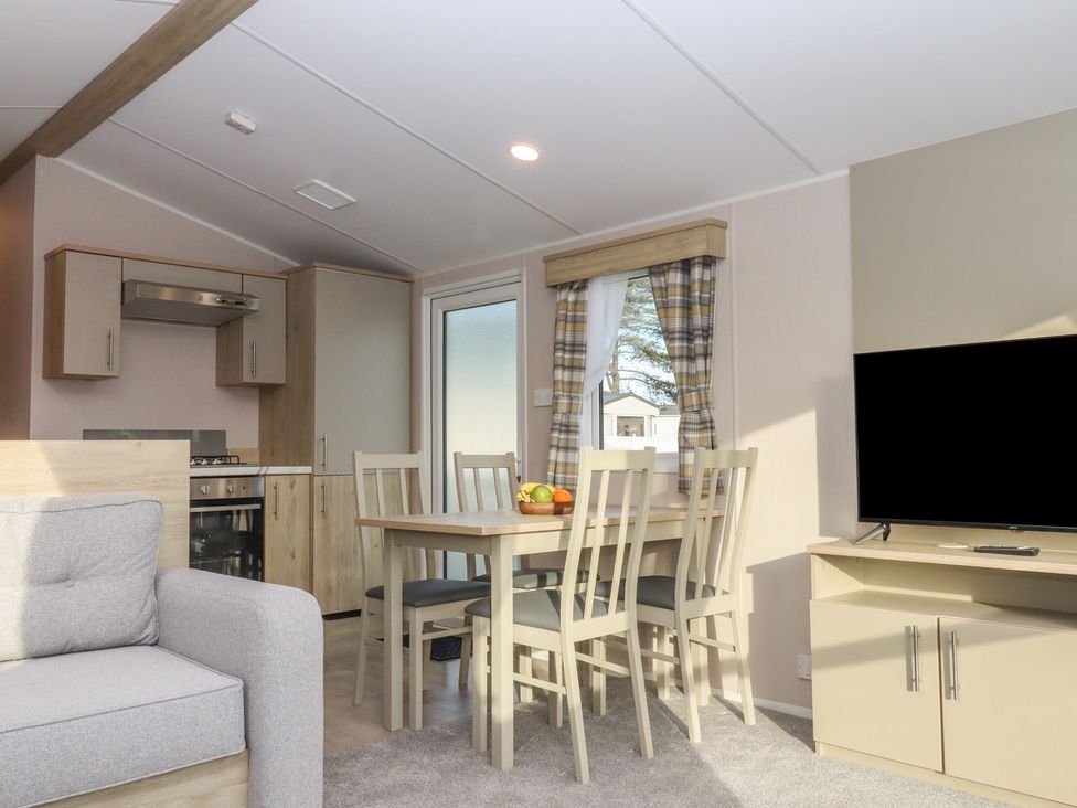 A living room with a dining table and kitchen area at Caravan B61 at Landscove Holiday Park Brixham