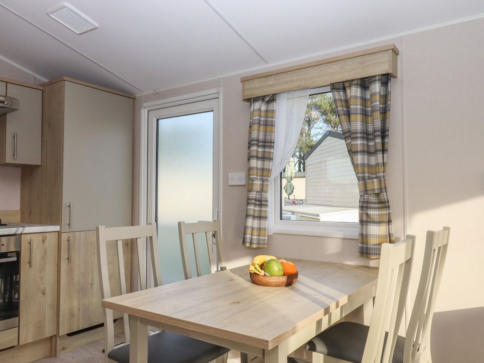 A kitchen with a table and chairs at Caravan B61 at Landscove Holiday Park Brixham