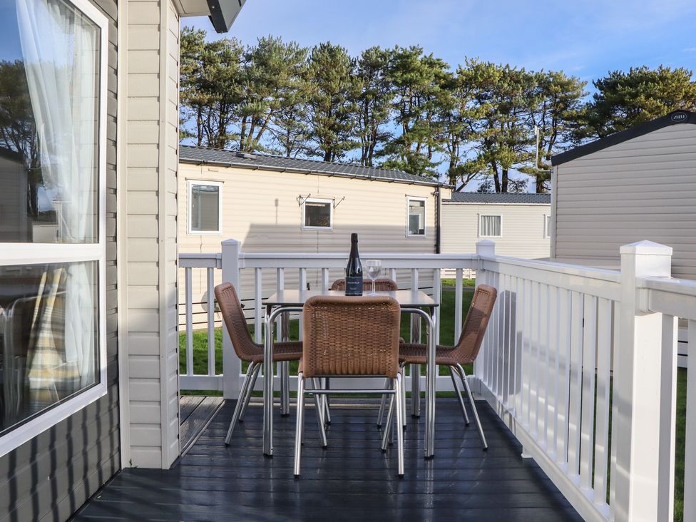 An outdoor seating area with a table and chairs at Caravan B61 at Landscove Holiday Park Brixham