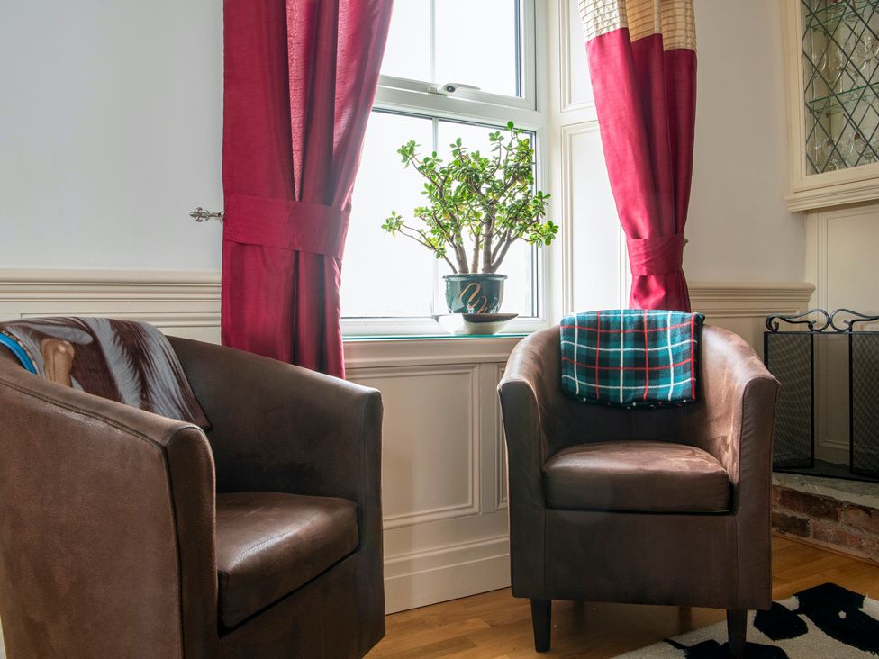 A living room with two armchairs and a window at Bank House Cottage in Lancaster