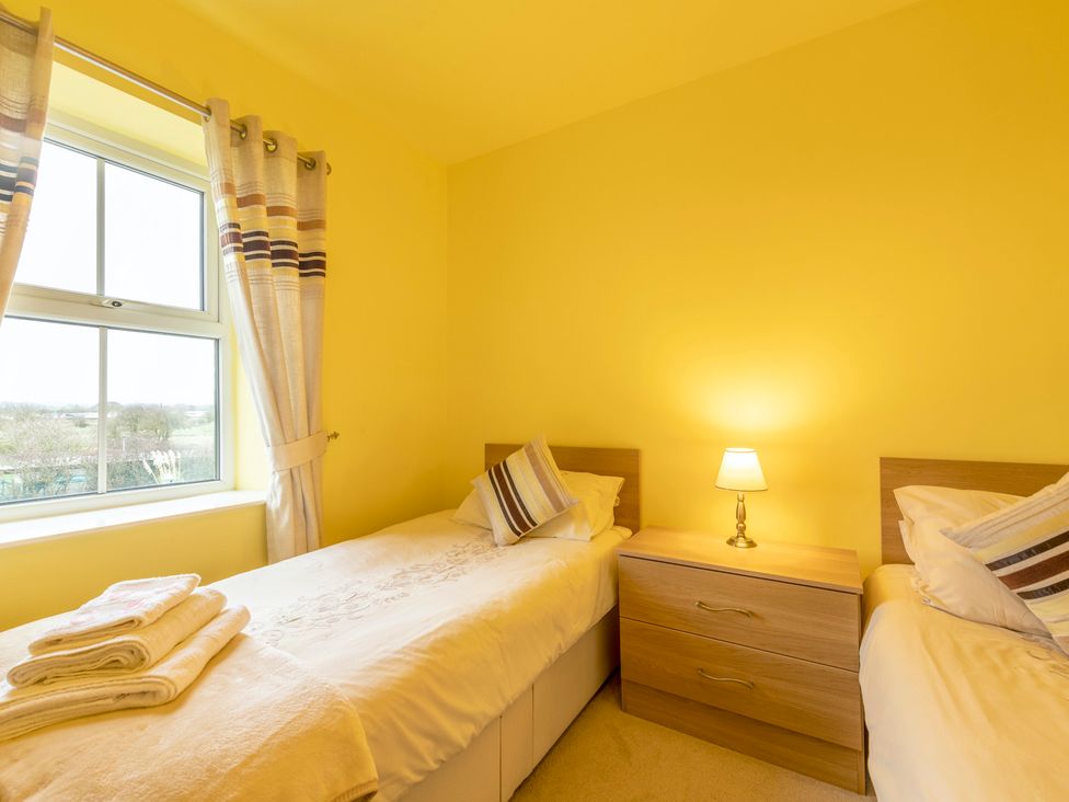A bedroom with twin beds and a nightstand at Bank House Cottage in Lancaster