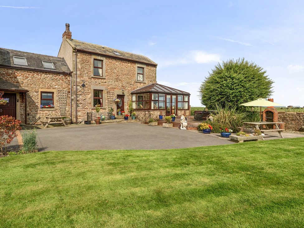 A house with a conservatory and garden at Bank House Cottage Glasson Dock