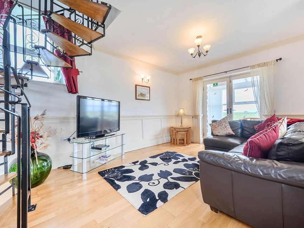 A living room with a sofa and television at Bank House Cottage Glasson Dock