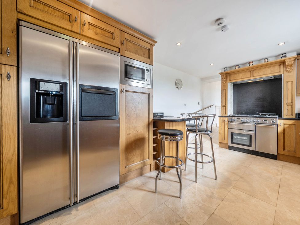 A kitchen with refrigerator and cooking appliances at Bank House Cottage in Glasson Dock
