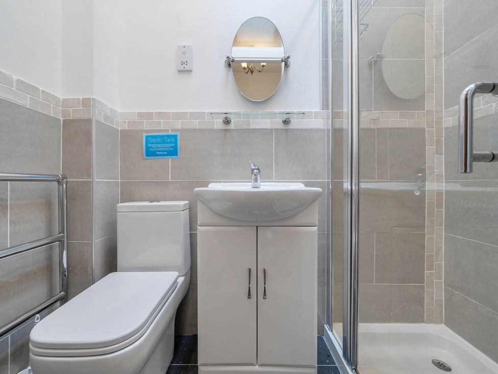 A bathroom with a toilet, sink, and shower at Bank House Cottage Glasson Dock