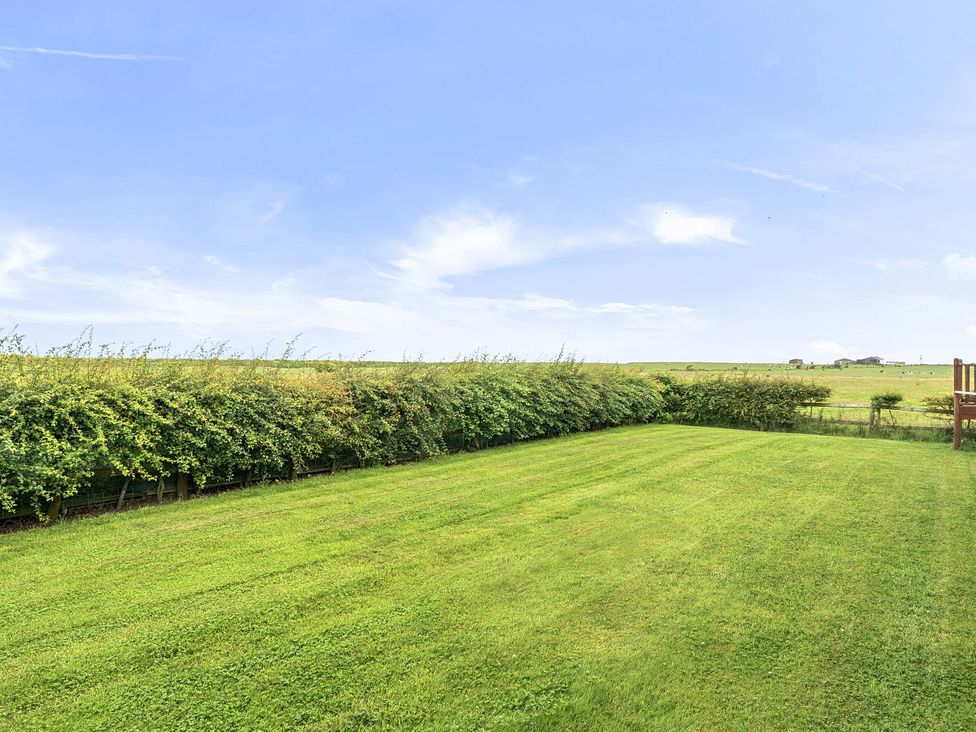 A garden with grass and hedges at Bank House Cottage Glasson Dock