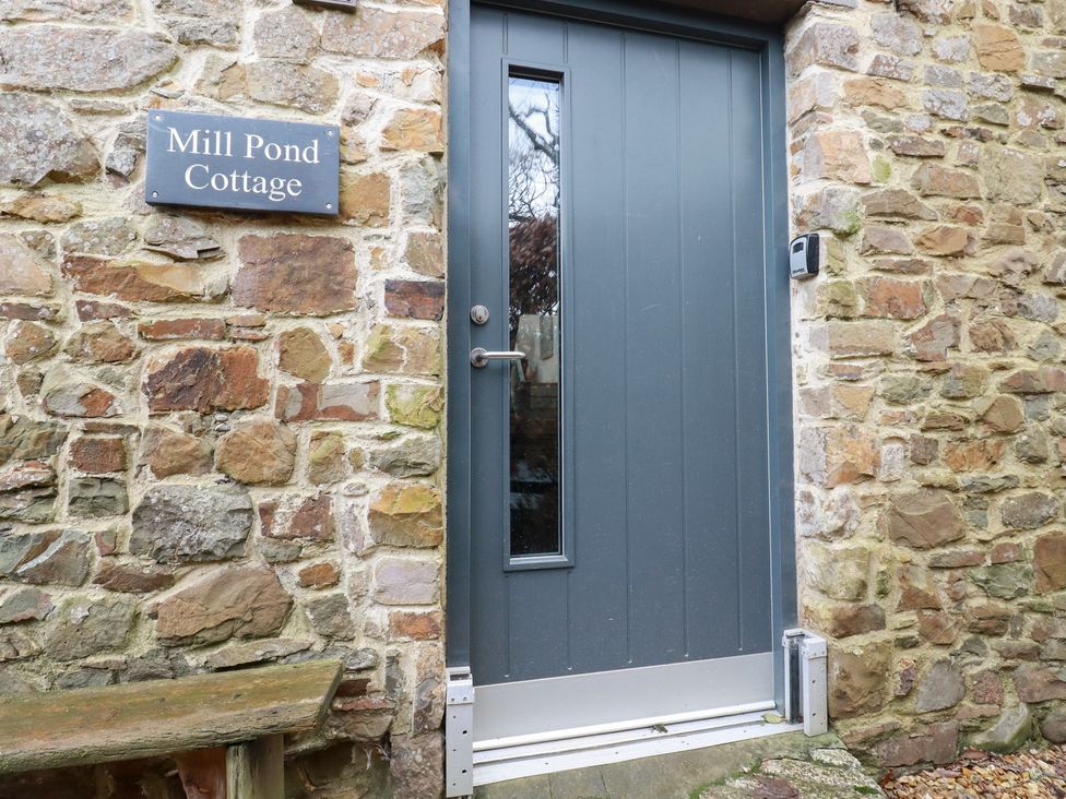 A front door and stone wall at Mill Pond Cottage in Bude