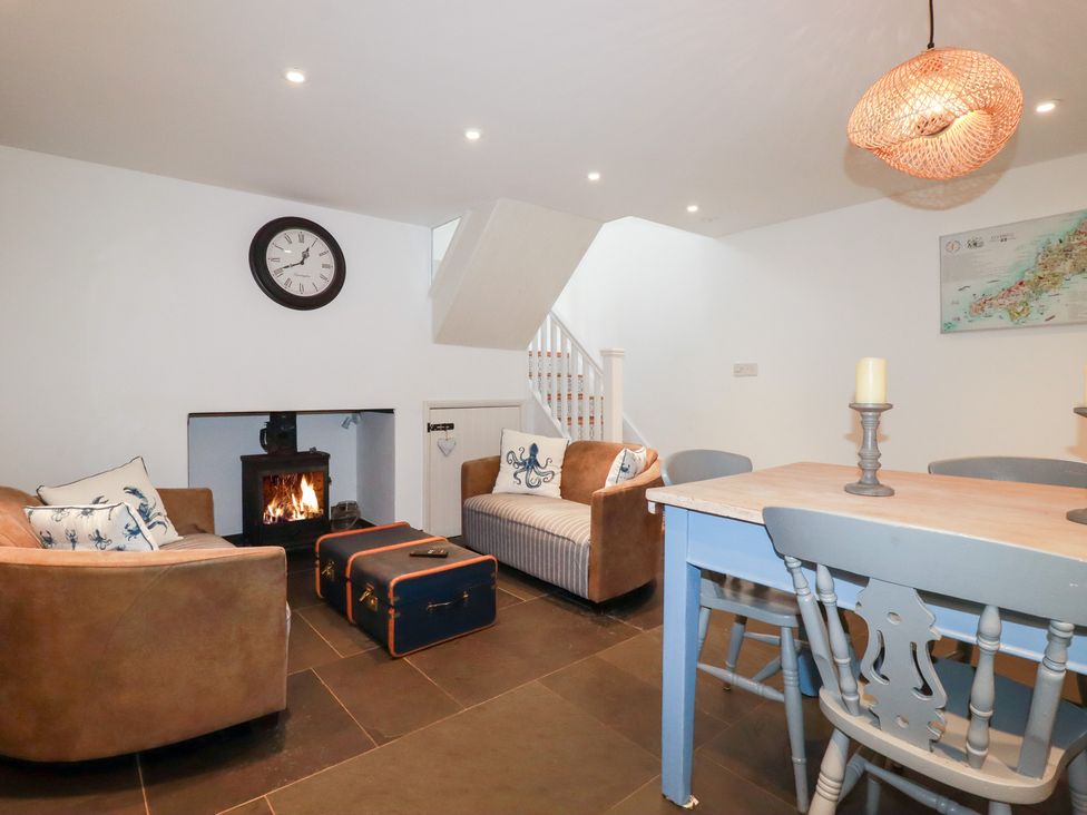 A living room with a fireplace and seating at Mill Pond Cottage in Bude
