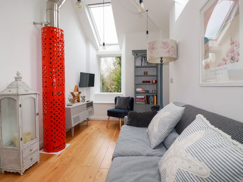 A living room with a sofa and television at Mill Pond Cottage in Bude