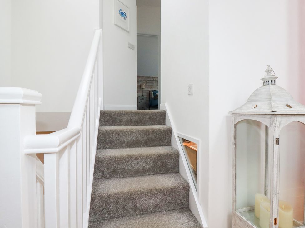 A staircase leading up with a lantern at Mill Pond Cottage, Bude