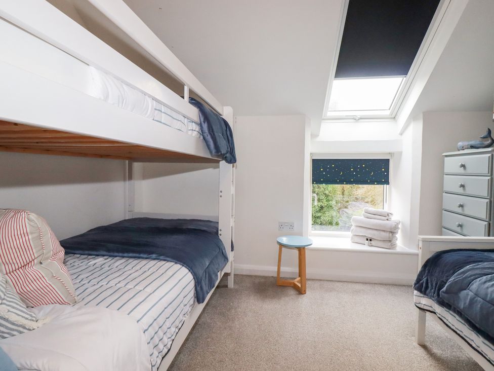 A bedroom with bunk beds and towels at Mill Pond Cottage in Bude