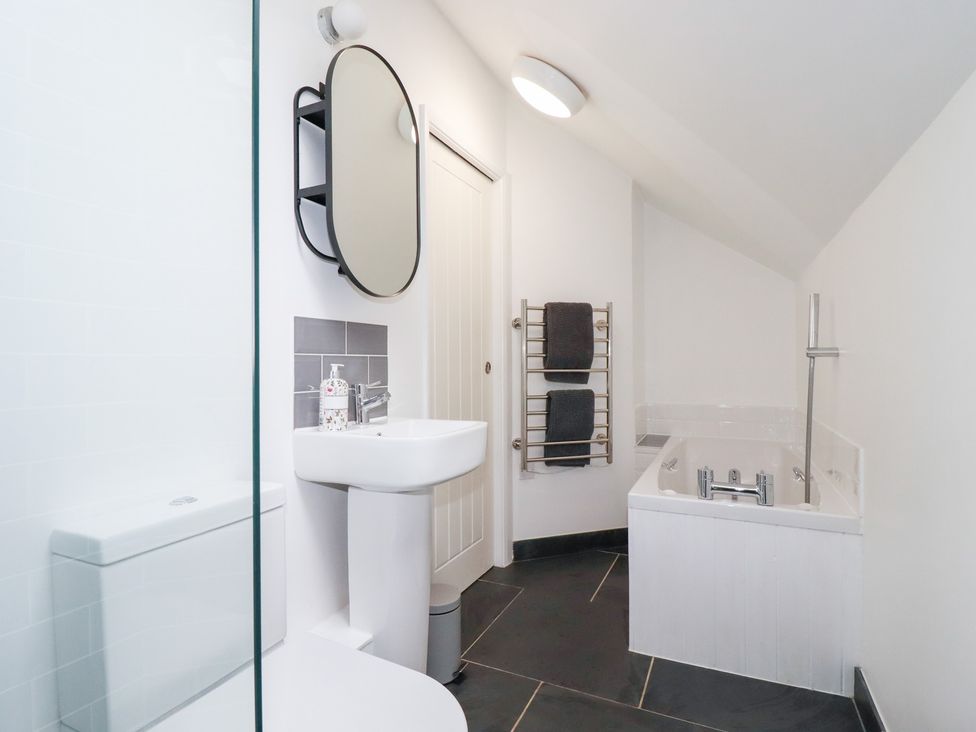A bathroom with a sink and bathtub at Mill Pond Cottage in Bude