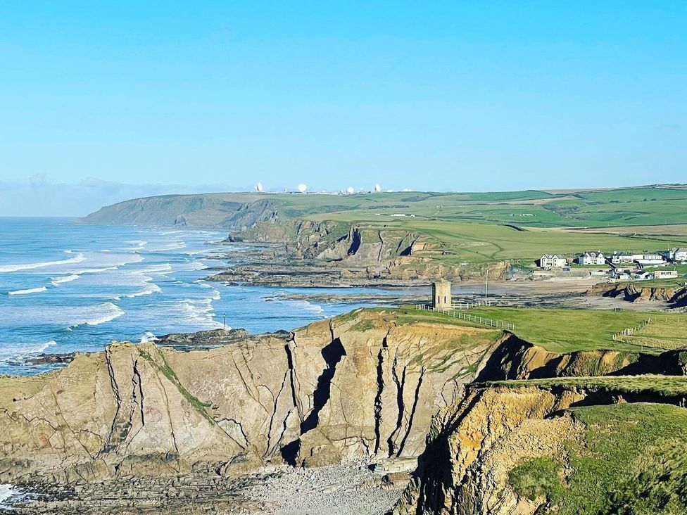 A coastal view featuring cliffs and ocean at Mill Pond Cottage in Widemouth Bay