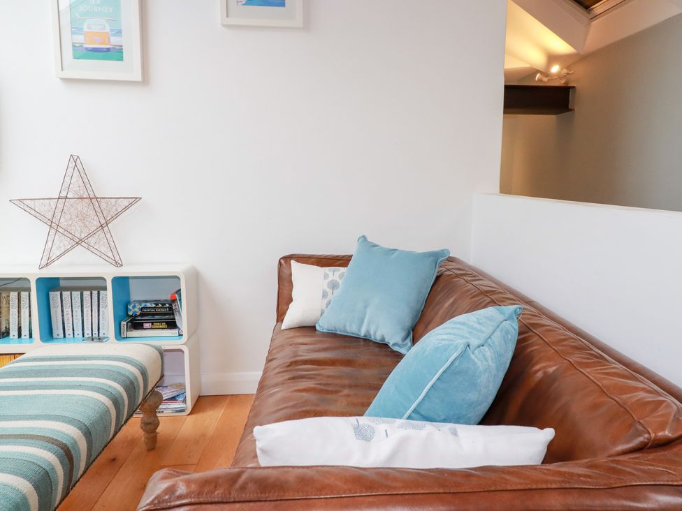 A living room with a brown couch and pillows at Meadow View in Bude