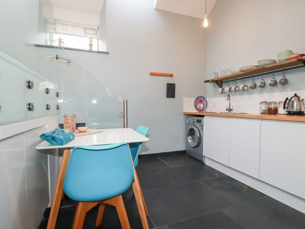 A kitchen with table and chair at Meadow View in Bude