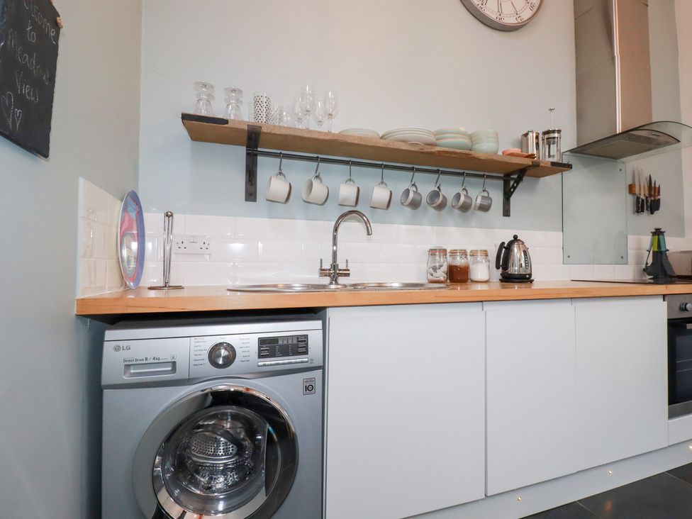 A kitchen with a washing machine and a sink at Meadow View in Bude