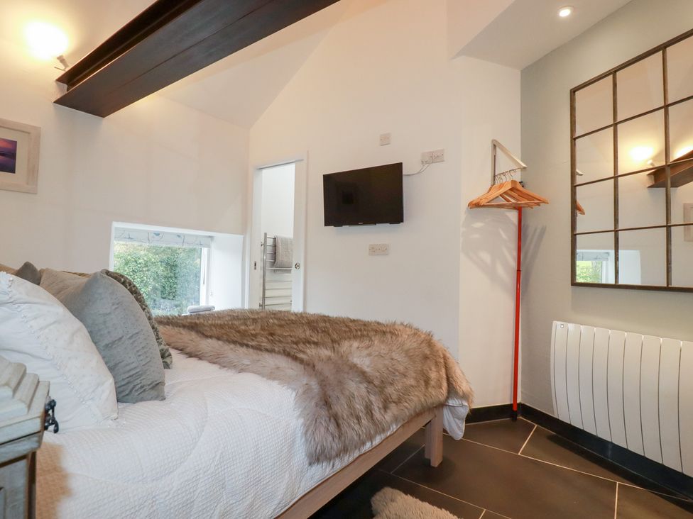 A bedroom with a bed and a television at Meadow View in Bude