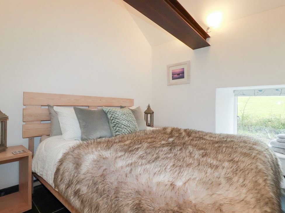 A bedroom with a bed and bedside table at Meadow View in Bude