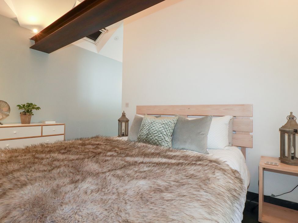 A bedroom with a bed and decorative pillows at Meadow View in Bude