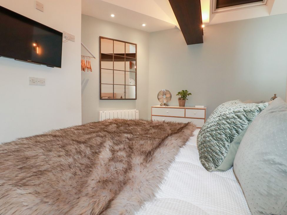 A bedroom with a bed and television at Meadow View in Bude