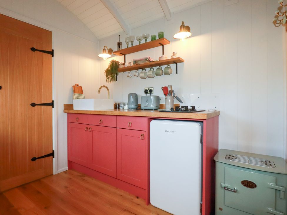 A kitchen with cabinets, sink, stove, and refrigerator at Bryar in Bude