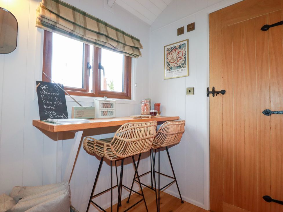 A kitchen with a table and stools at Bryar in Bude