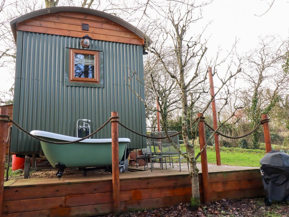 A cabin with a bath tub and outdoor seating at Bryar in Bude