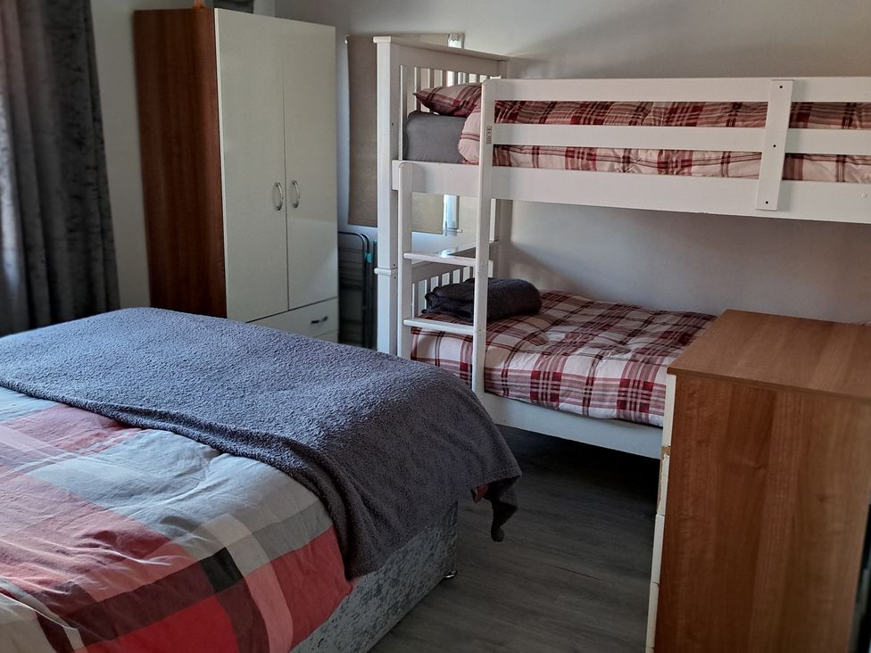 A bedroom with a double bed and bunk bed at Sea View Retreat in Bridlington