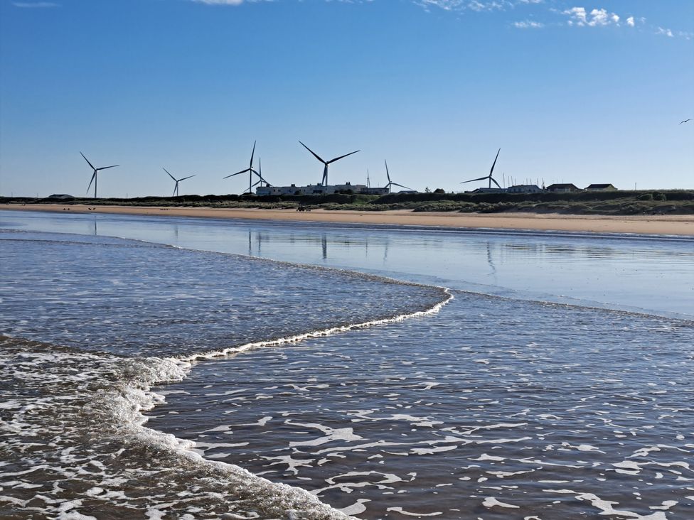 A beach with wind turbines in the background at Sea View Retreat in Bridlington