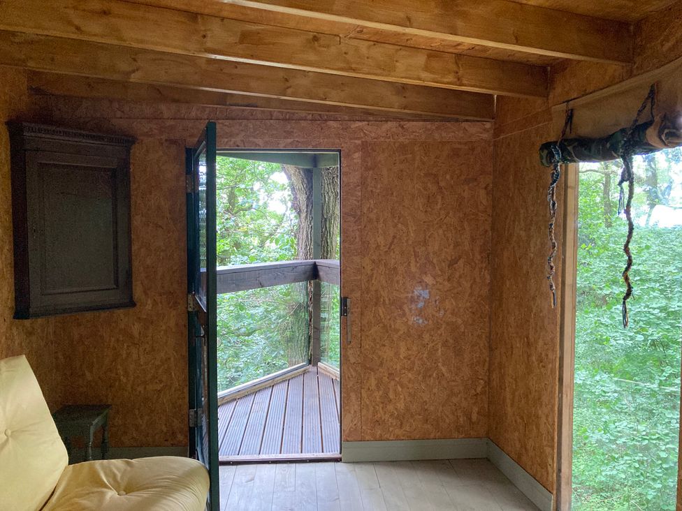 An interior view with a door and wooden floor at The Tree House in the Woods Longhope